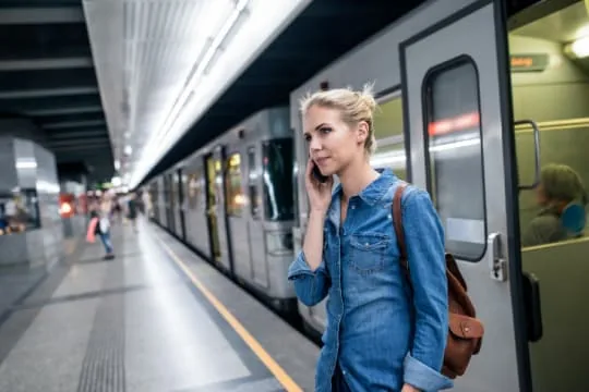 Voyageuse au téléphone sur le quai d’une gare