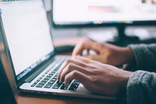 Mains d’une personne utilisant le clavier d’un ordinateur portable