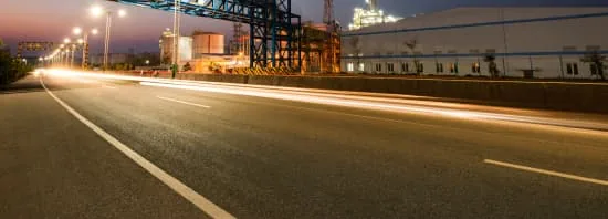 Route éclairée la nuit avec les traînées lumineuses de véhicules