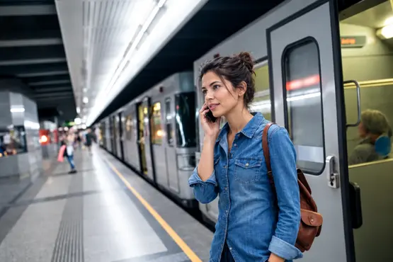 Voyageuse au téléphone sur le quai d’une gare