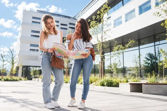 Deux visiteuses consultent une carte pendant leur promenade en ville.